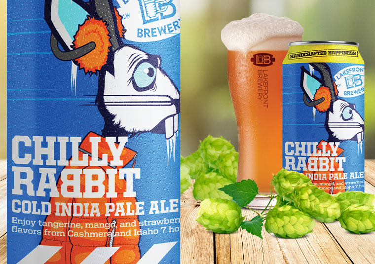 Image of Chilly Rabbit Cold IPA can in the foreground, with hop cones and a Chilly Rabbit Cold IPA can next to a glass of beer on a table top in the background