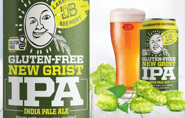 Image of New Grist IPA can in the foreground, next to a glass of beer, with hop cones and New Grist IPA cans on a table top in the background